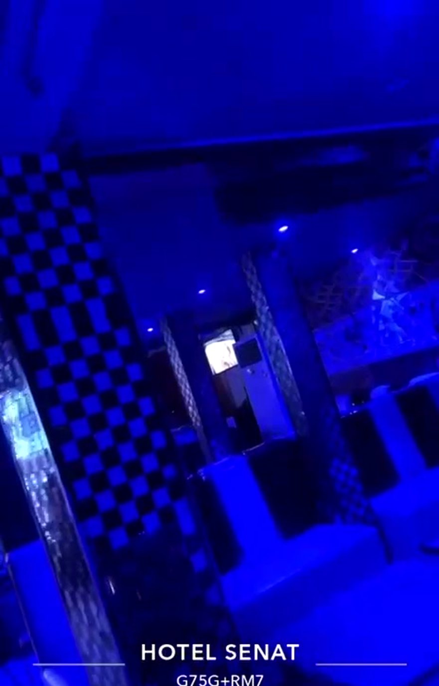 Banquettes capitonnées du lounge sous les néons bleus